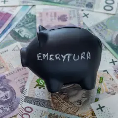 Skarbonka z napisem "EMERYTURA" na tle polskich banknotów. Zastanawiasz się, jaka emerytura przy zarobkach 7000 brutto?