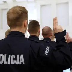 Policjanci w mundurach podnoszą ręce. Czy ich zarobki w policji są adekwatne do służby?