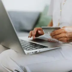Kobieta z kartą płatniczą na laptopie sprawdza, do kiedy ZUS.
