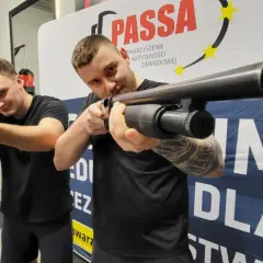 Dwóch mężczyzn ćwiczy celowanie z broni na kursie na ochroniarza.