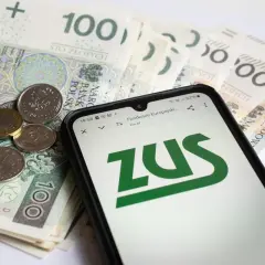 Złotówki i monety obok telefonu z logo ZUS. Sprawdzasz, czy zasiłek pogrzebowy 6000 zł wystarczy na pokrycie kosztów.