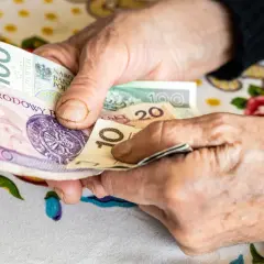 Dłonie emeryta liczą banknoty. Może to być zwrot podatku dla emerytów, który pomoże w codziennych wydatkach.