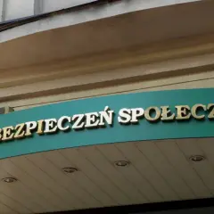 Złoty napis "ZAKŁAD UBEZPIECZEŃ SPOŁECZNYCH" na zielonym tle.