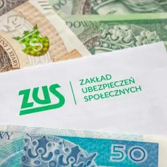 Koperta ZUS na tle polskich banknotów symbolizuje ubezpieczenie chorobowe i finansowe bezpieczeństwo.
