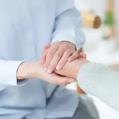 Dwie osoby trzymają się za ręce, symbolizując wsparcie. Może to być związane ze świadczeniem wspierającym 2026 tabela.