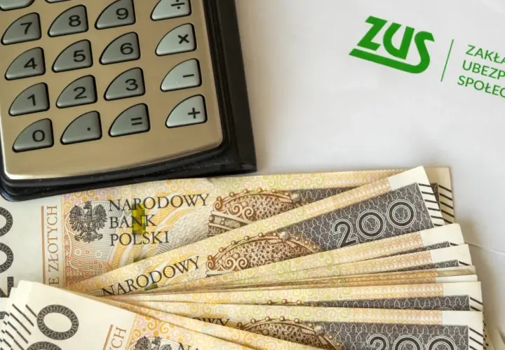 Kalkulator, banknoty 200 zł i logo ZUS. Obliczenia dotyczące tego, ile wynosi dodatek do emerytury za warunki szkodliwe.