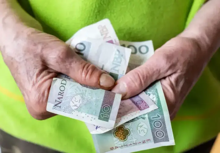 Dłonie trzymają polskie banknoty. Czy to już przyszła renta socjalna 2026?
