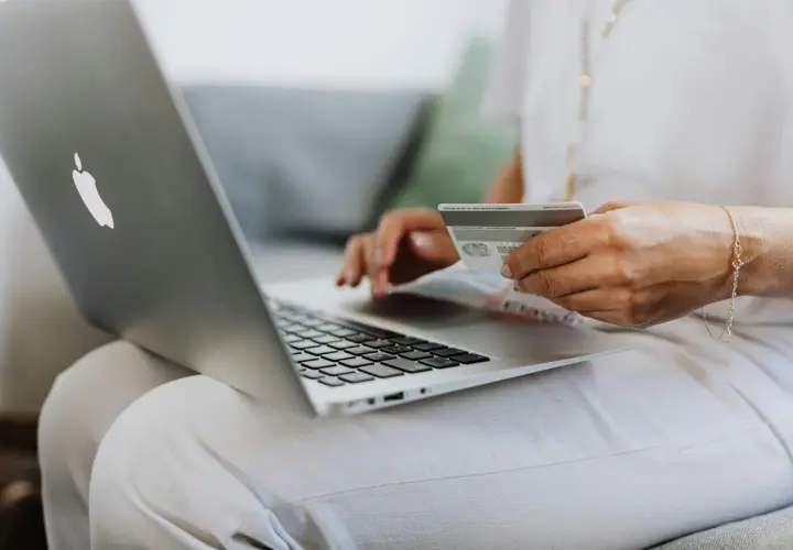 Kobieta z kartą płatniczą na laptopie sprawdza, do kiedy ZUS.