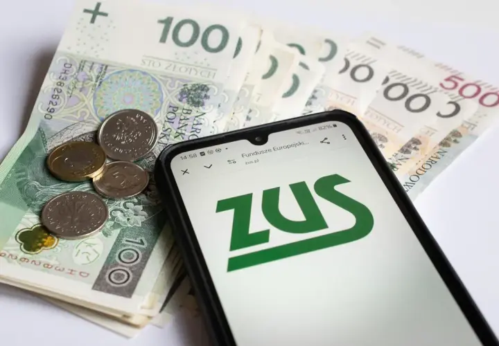 Złotówki i monety obok telefonu z logo ZUS. Sprawdzasz, czy zasiłek pogrzebowy 6000 zł wystarczy na pokrycie kosztów.