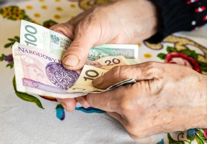 Dłonie emeryta liczą banknoty. Może to być zwrot podatku dla emerytów, który pomoże w codziennych wydatkach.