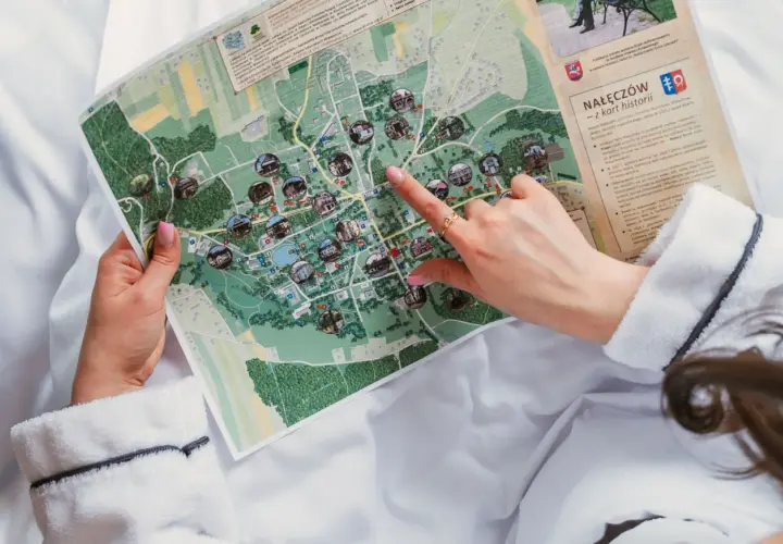 Ręka wskazuje na mapę Nałęczowa, planując dzień wolny i zwiedzanie atrakcji.