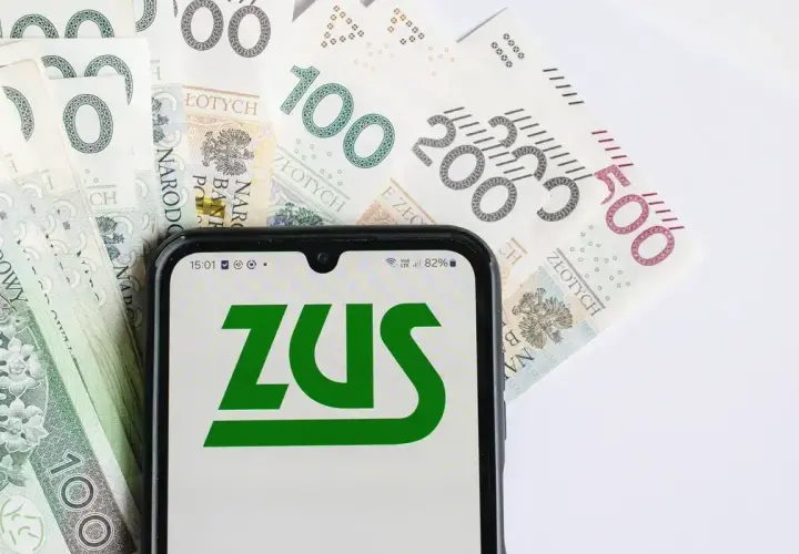 ZUS waloryzacja emerytur 2026 - tabela. Na ekranie telefonu widnieje logo ZUS, a w tle polskie banknoty.