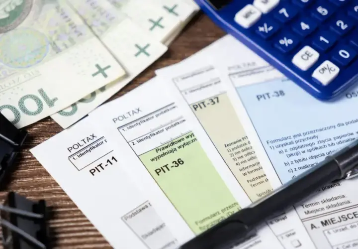 Polskie formularze podatkowe PIT-11, PIT-36, PIT-37, PIT-38, banknoty i kalkulator. Czas rozliczyć dochód.