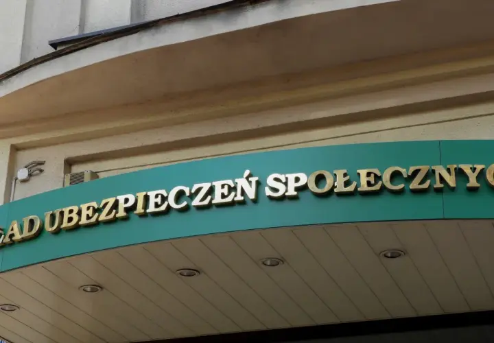 Złoty napis "ZAKŁAD UBEZPIECZEŃ SPOŁECZNYCH" na zielonym tle.