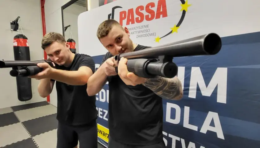Dwóch mężczyzn ćwiczy celowanie z broni na kursie na ochroniarza.