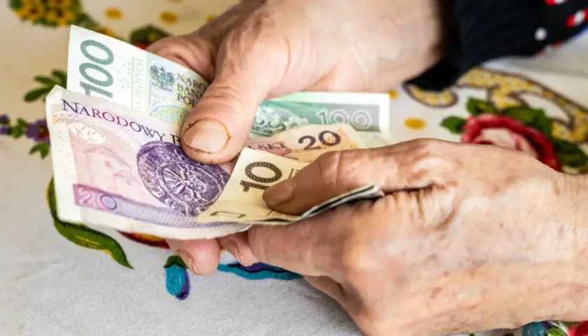 Dłonie liczą pieniądze. Zmagania z niepełnosprawnością sprzężoną utrudniają codzienne czynności, jak zarządzanie finansami.