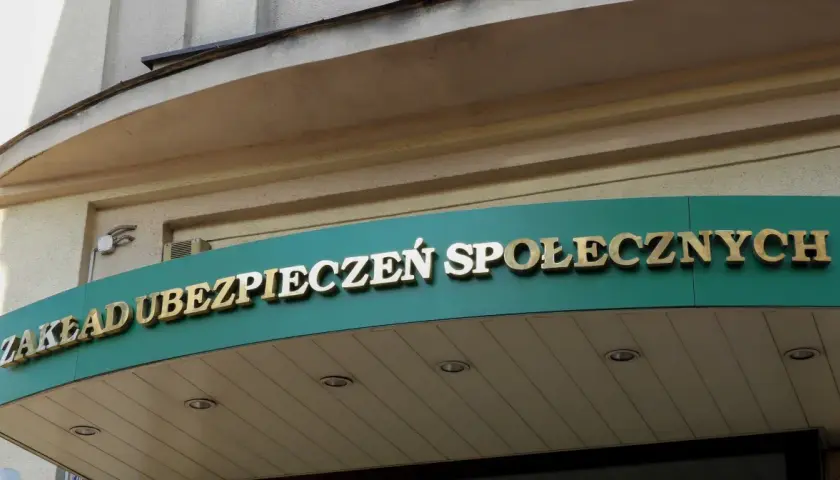Złoty napis "ZAKŁAD UBEZPIECZEŃ SPOŁECZNYCH" na zielonym tle.