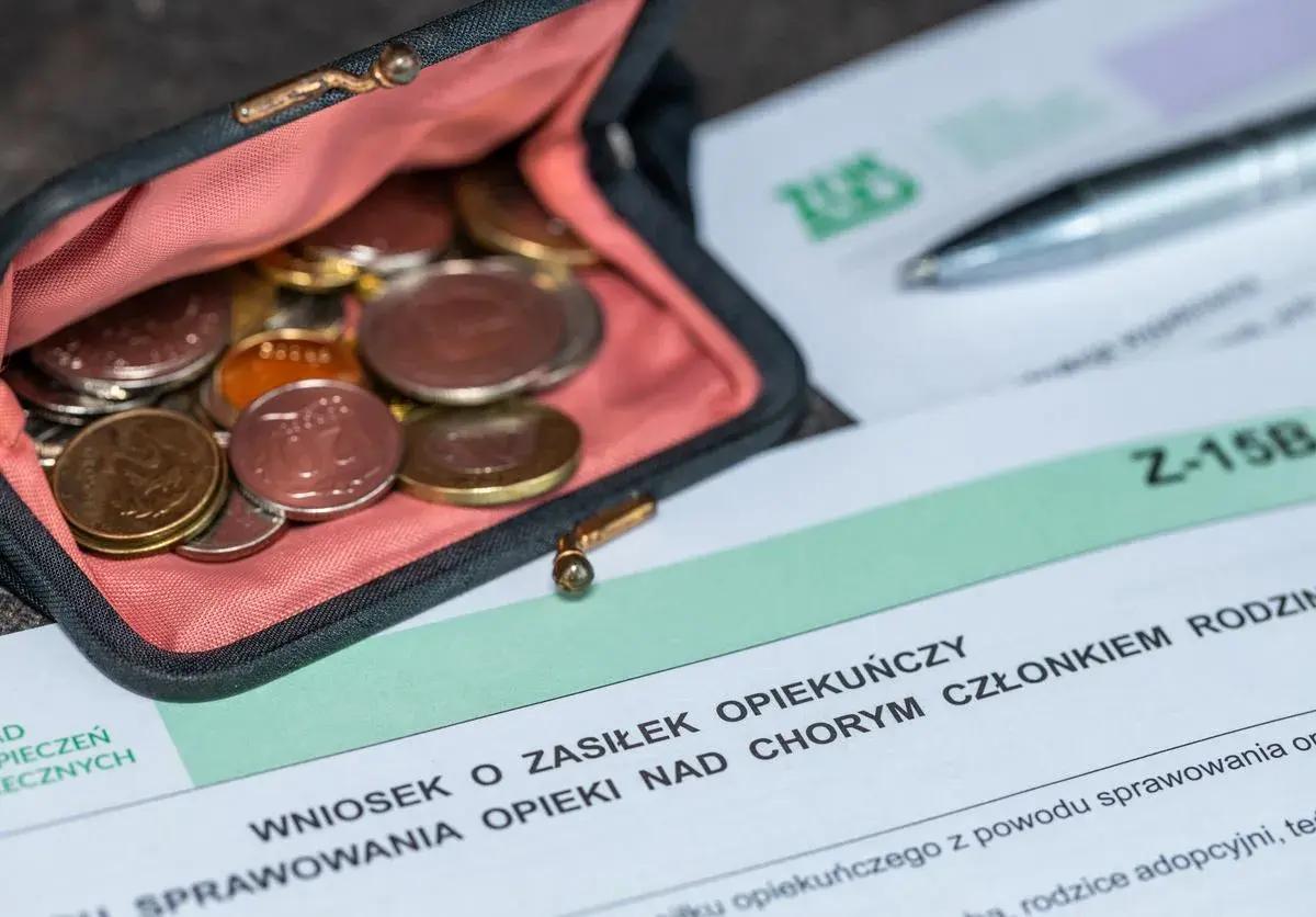 Portmonetka z monetami obok formularza "Wniosek o zasiłek opiekuńczy".