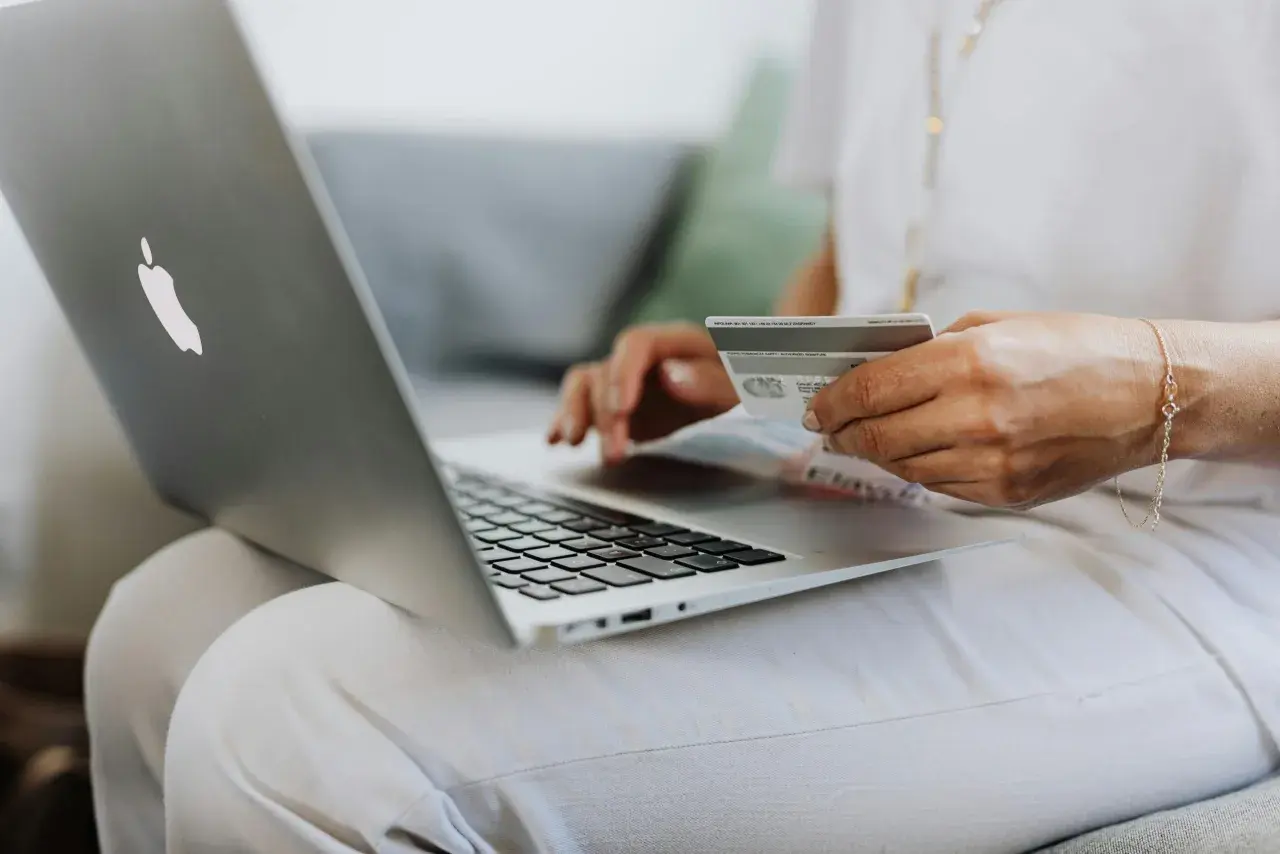 Kobieta z kartą płatniczą na laptopie sprawdza, do kiedy ZUS.