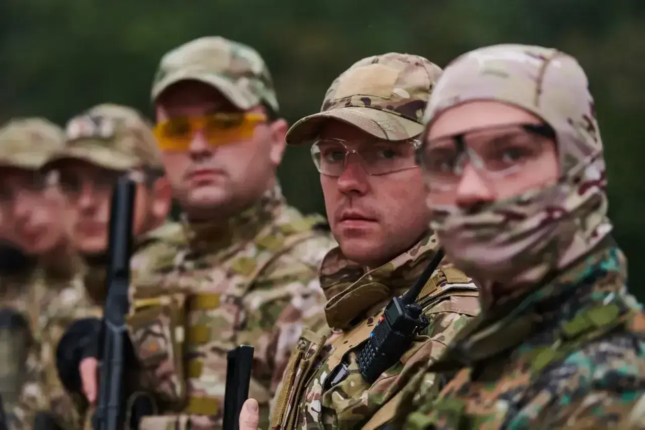 Grupa żołnierzy w kamuflażu, jeden z nich to starszy szeregowy specjalista, gotowi do akcji.