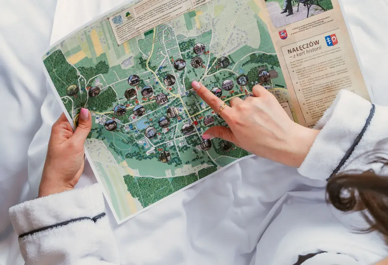 Ręka wskazuje na mapę Nałęczowa, planując dzień wolny i zwiedzanie atrakcji.