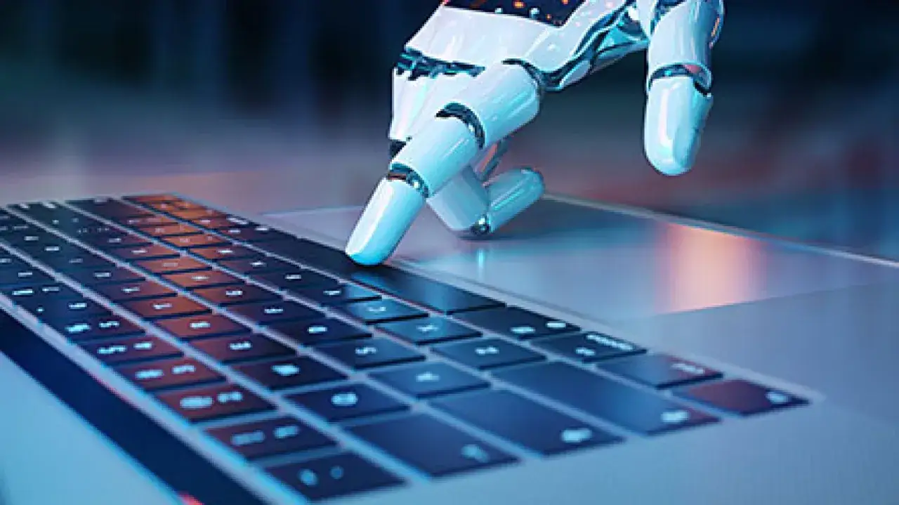Robotyczna dłoń pisze na klawiaturze. To przyszłość, która czeka na każdego, kto zdaje egzamin na technika informatyka.